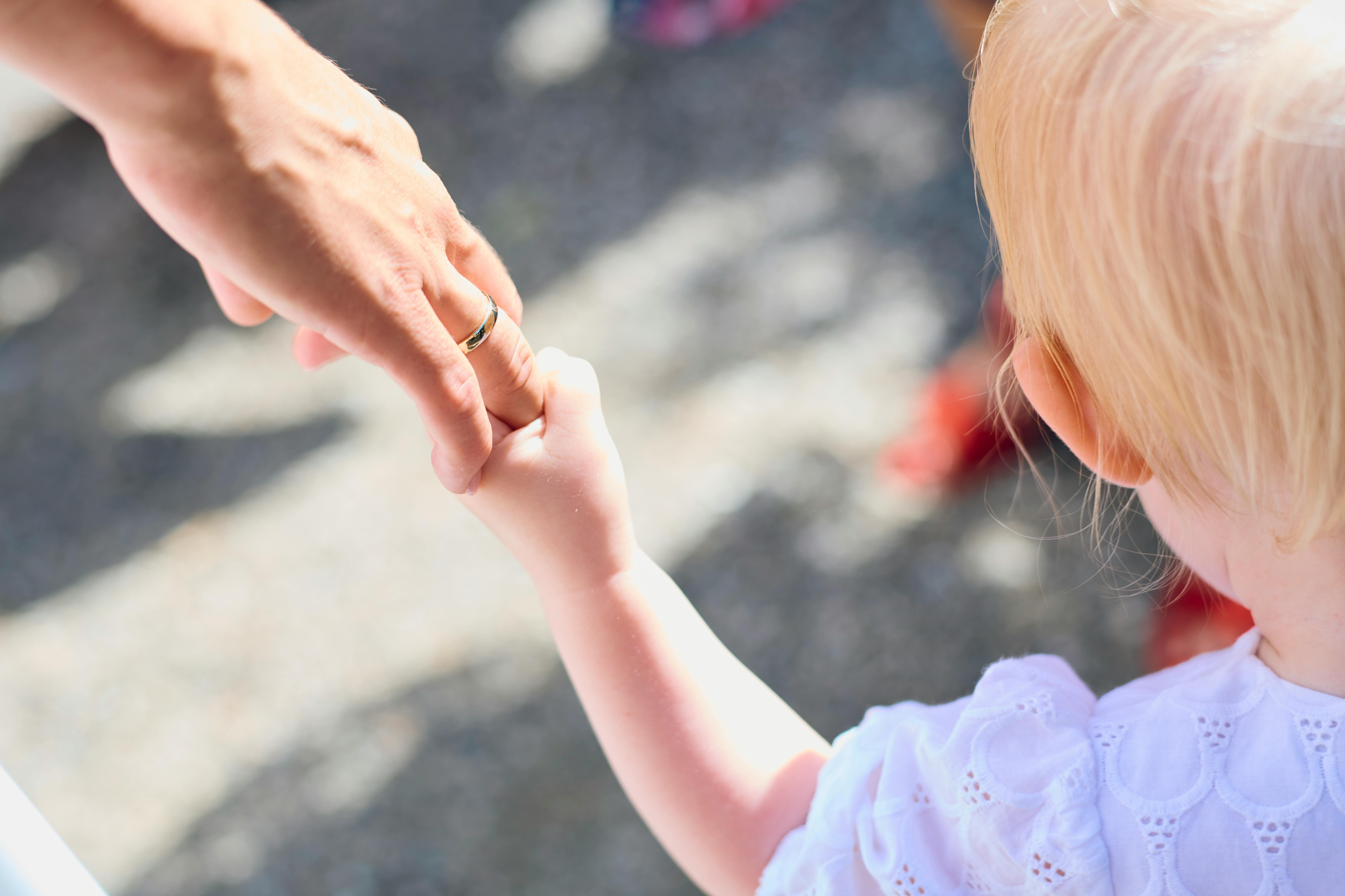 Caregiver and child holding hands